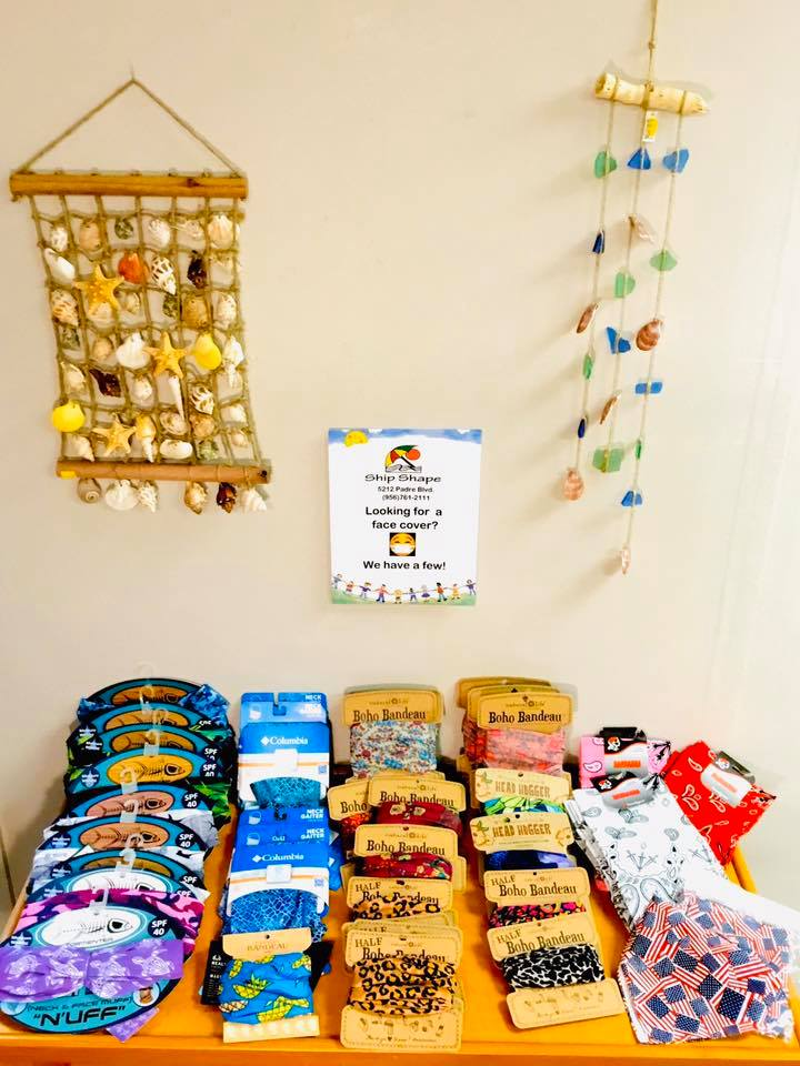 Display table of SPF neck gaiters, boho bandeau head wraps and Columbia neck gaiters in tropical and floral prints