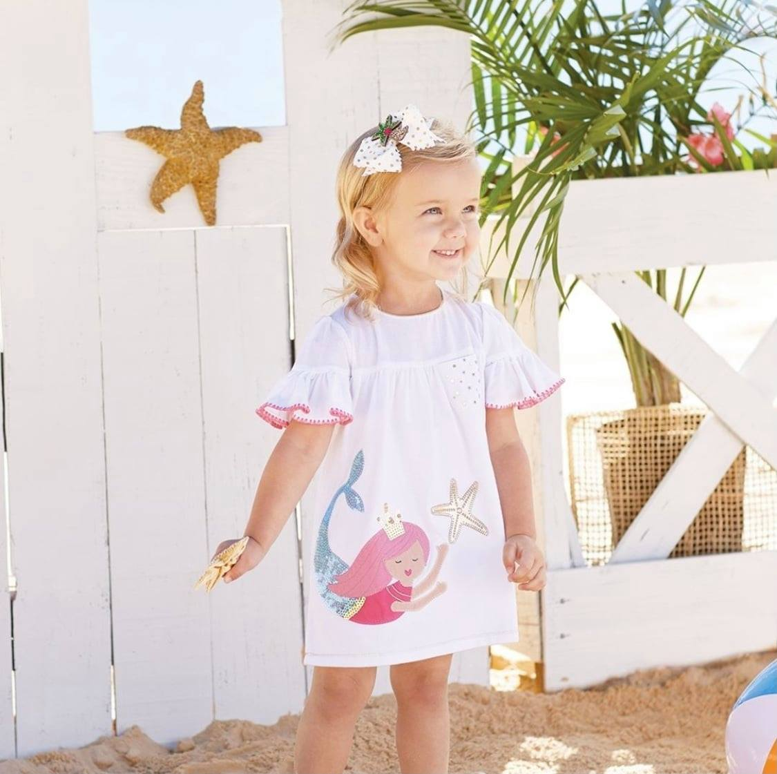 Little girl in mermaid beach dress at the shore