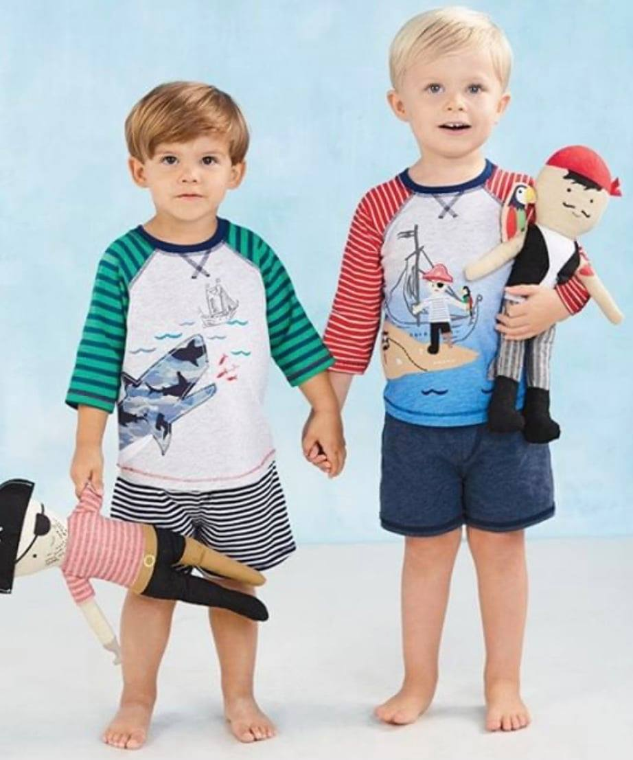 Two boys in nautical themed play sets holding pirate dolls