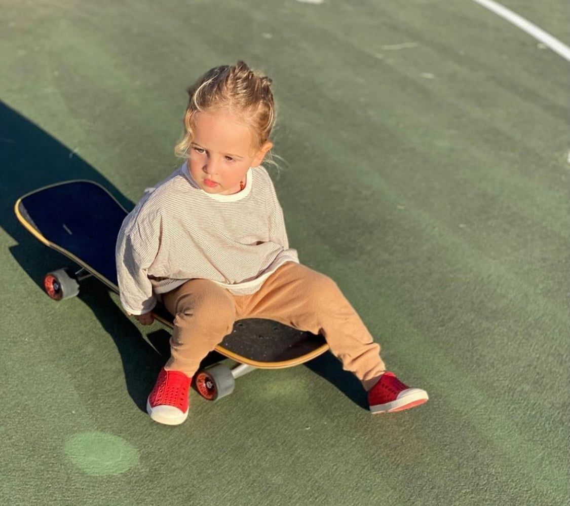 Kid on skateboard wearing red Native Jefferson sneakers