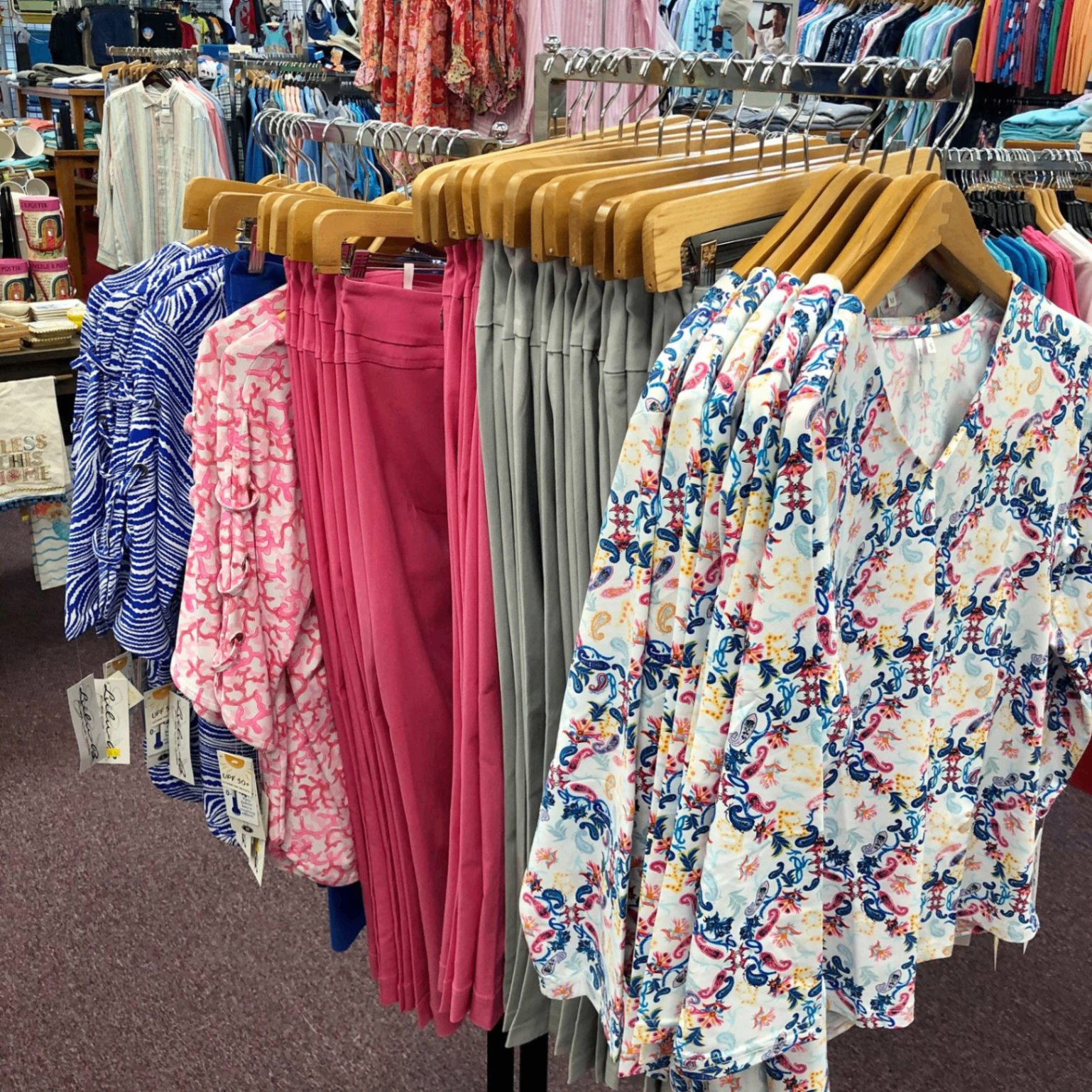 Rack of Lulu-B paisley camp shirts and pull-on skirts in pink, blue, gray, and white print