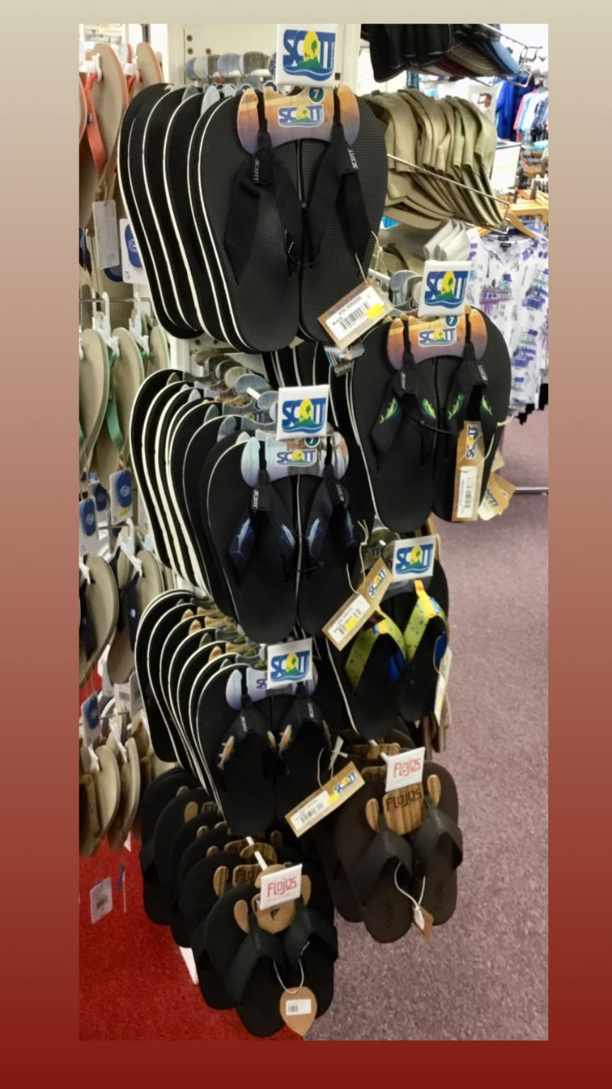 Wall of Scott Hawaii and Flojos black rubber strap flip flops at the boutique