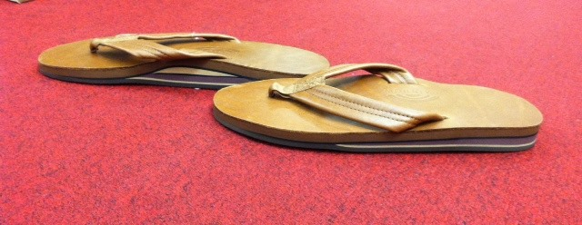 Southern Tide tan leather flip flops displayed on red carpet