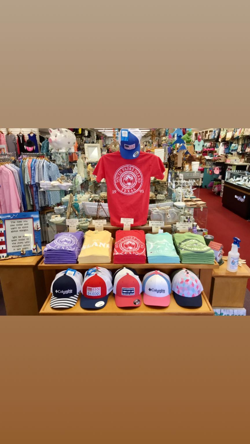 South Padre Island 1993 seal tees stacked in red, yellow, purple and teal with Columbia and Performance Fishing Gear trucker caps below